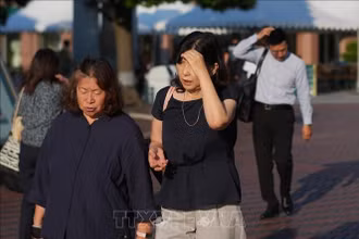 Người dân di chuyển trên đường phố dưới trời nắng nóng tại Tokyo, Nhật Bản. (Ảnh: THX/TTXVN)