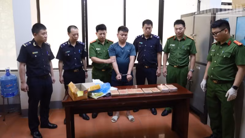 Các lực lượng chức năng bắt giữ đối tượng Hoàng Văn Cường cùng tang vật là 10 bánh heroin.