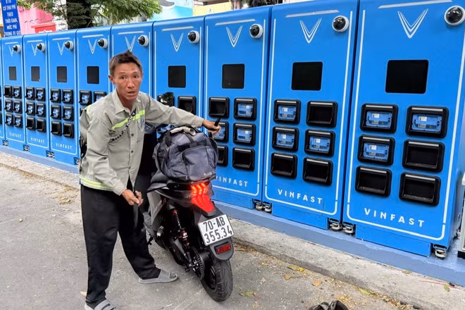 Người sử dụng xe máy điện sử dụng tủ đổi pin. (Ảnh: VÕ LÊ)