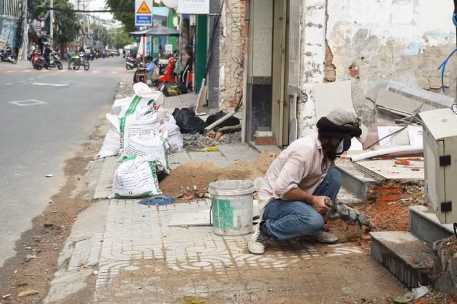 Người dân phường Vĩnh Hội bàn giao mặt bằng, sửa sang nhà ở chuẩn bị thi công Dự án cầu đường Nguyễn Khoái. (Ảnh: THẾ ANH)