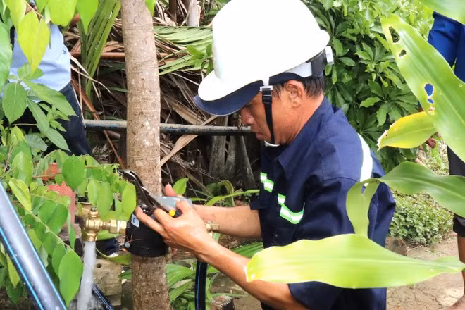 Nhân viên Xí nghiệp Cấp nước Cần Giờ gắn đồng hồ nước tại cù lao Mỹ Khánh để bảo đảm duy trì cung cấp nước sạch liên tục cho người dân. (Ảnh: QUÝ HIỀN)