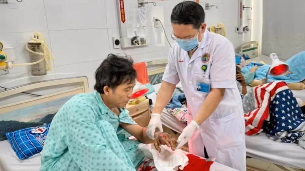 Bác sĩ kiểm tra bàn tay của bệnh nhân sau ca phẫu thuật nối chi phức tạp. 
