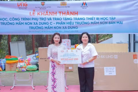 Bà Trương Cẩm Thanh, Phó Tổng Giám đốc Công ty Cổ phần Tập đoàn VNG, Chủ tịch Hội đồng Quản lý kiêm Giám đốc Quỹ Kiến tạo Ước mơ (áo trắng, bên phải) trao tặng các thiết bị, đồ dùng học tập cho điểm trường Xa Dung C, phân hiệu Mầm non Ban Mai - Trường mầm non Xa Dung. (Ảnh: VNG)