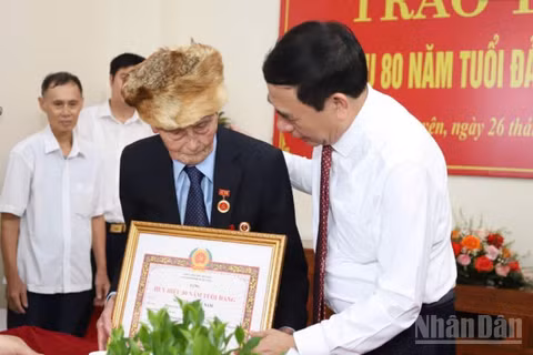 Đại tướng Phan Văn Giang, Ủy viên Bộ Chính trị, Phó Thủ tướng Chính phủ, Bộ trưởng Quốc phòng trao Huy hiệu cho đảng viên lão thành Nguyễn Quang Nam. (Ảnh: DUY ĐỨC)