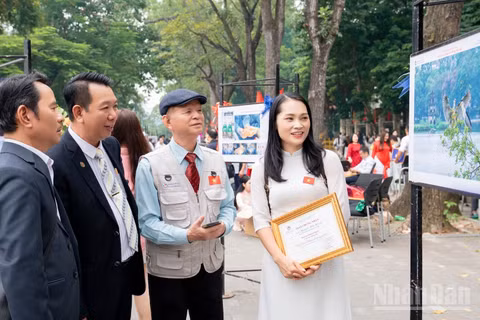 Tại không gian trưng bày, những người làm nhiếp ảnh cùng nhau quan sát, trao đổi về chuyện nghề.