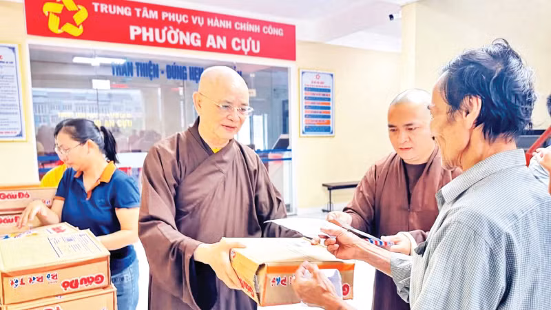 Hòa thượng Thích Huệ Phước (bên trái) trao quà hỗ trợ người dân vùng bị lũ lụt tại phường An Cựu, TP Huế.