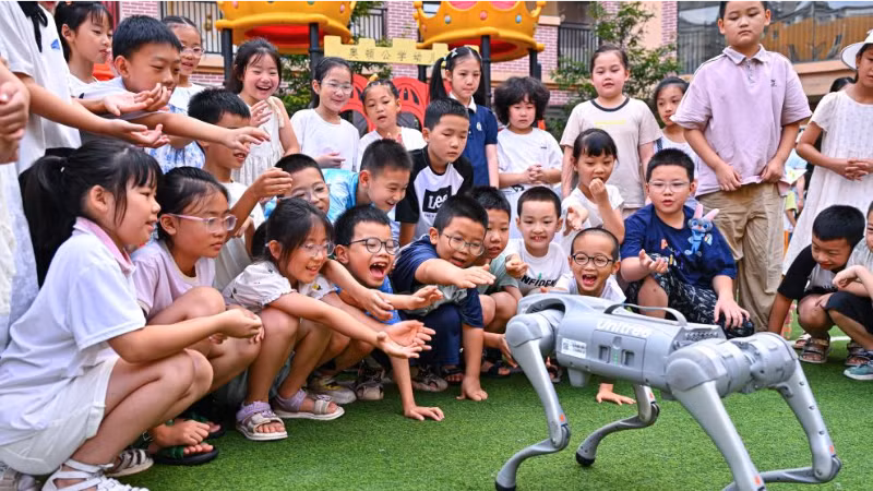 Trẻ em “giao lưu” với chó robot ở huyện Nhân Thọ, thành phố My Sơn, tỉnh Tứ Xuyên, Trung Quốc. (Ảnh: Tân Hoa Xã)