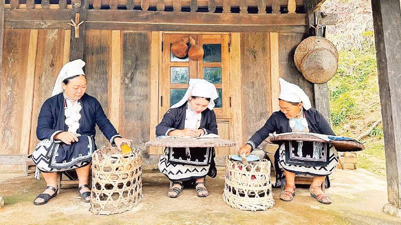 Các nghệ nhân ở bản Hoài Khao (Cao Bằng) thực hiện kỹ thuật thêu và in hoa văn bằng sáp ong.