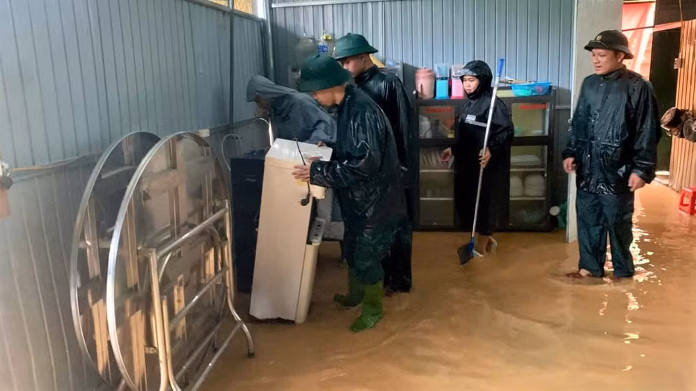 Cán bộ, chiến sĩ Đồn Biên phòng Nhôn Mai hỗ trợ người dân di dời tài sản. (Ảnh: LÊ THẠCH)
