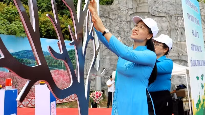 Lãnh đạo Hội Liên hiệp Phụ nữ tỉnh Điện Biên gửi thông điệp yêu thương, bảo vệ phụ nữ, trẻ em gái bằng cách phòng chống bạo lực gia đình trên "cây yêu thương". (Ảnh: LAN PHƯƠNG)
