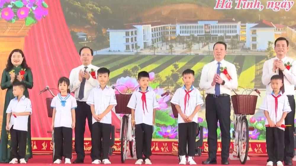 Các đồng chí lãnh đạo tỉnh Hà Tĩnh tặng quà các em học sinh nghèo vượt khó tại Lễ khánh thành Trường phổ thông nội trú tiểu học và trung học cơ sở Sơn Kim 1. (Ảnh: NT)