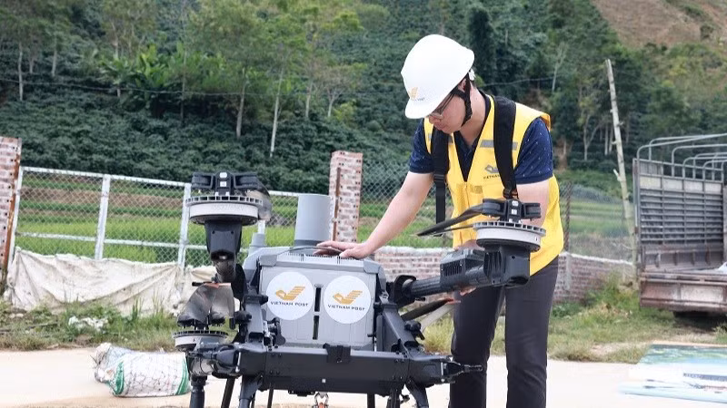 Nhân viên bưu điện thực hiện các thao tác kỹ thuật trước khi điều khiển UAV cất cánh bay thử nghiệm tại xã Mường Ảng. (Ảnh: Bưu điện Việt Nam)