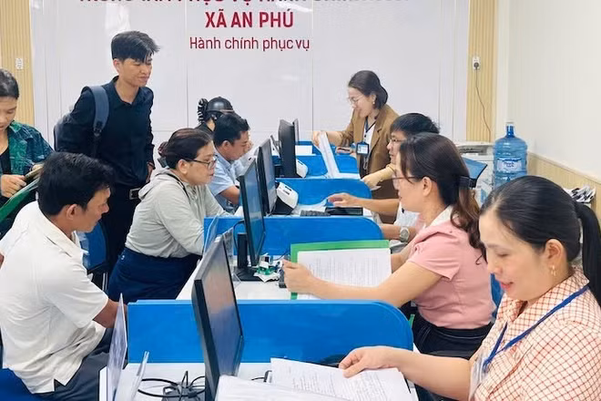 Cán bộ, viên chức xã An Phú hướng dẫn thủ tục hành chính cho người dân vùng biển Quảng Ngãi. (Ảnh ĐÔNG HUYỀN)