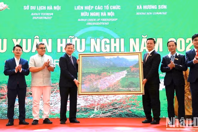 Đại diện lãnh đạo xã Hương Sơn tặng Đoàn đại biểu Du xuân bức tranh về suối Yến trong quần thể di tích Hương Sơn.