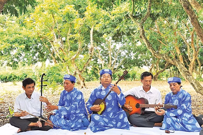 Các nghệ nhân Câu lạc bộ Đờn ca tài tử phường Hiệp Thành, tỉnh Cà Mau truyền dạy nghề cho các thành viên mới. (Ảnh: TTXVN)