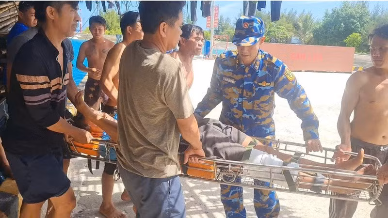 Đưa ngư dân Phạm Văn Minh vào Bệnh xá đảo Sinh Tồn cấp cứu. (Ảnh: CTV HQ) 