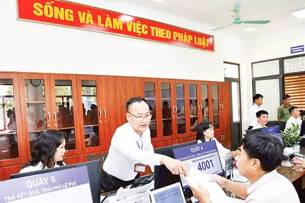 Cán bộ hướng dẫn người dân thực hiện thủ tục hành chính tại xã Phúc Thịnh, Hà Nội (Ảnh PHẠM HÙNG)