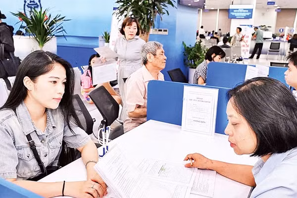 Cán bộ Trung tâm Phục vụ hành chính công Thành phố Hà Nội hỗ trợ doanh nghiệp, hộ kinh doanh làm thủ tục.
