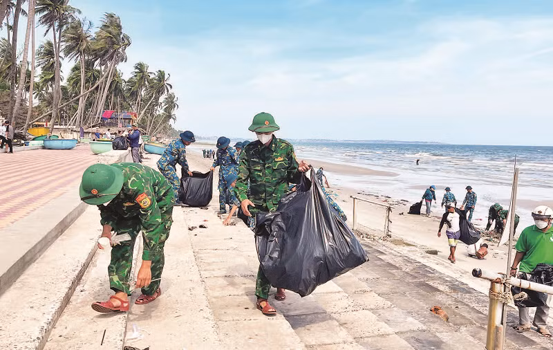 Các lực lượng đoàn thể cùng với người dân tham gia nhặt rác bãi biển bảo vệ môi trường tại phường Mũi Né.