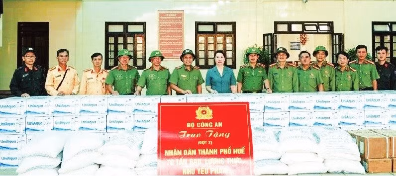 Thiếu tướng Nguyễn Hồng Nguyên (thứ 6 từ trái qua), Phó Chánh Văn phòng Bộ Công an trao 70 tấn gạo, lương thực và nhu yếu phẩm hỗ trợ người dân thành phố Huế. Ảnh HỒNG NHUNG
