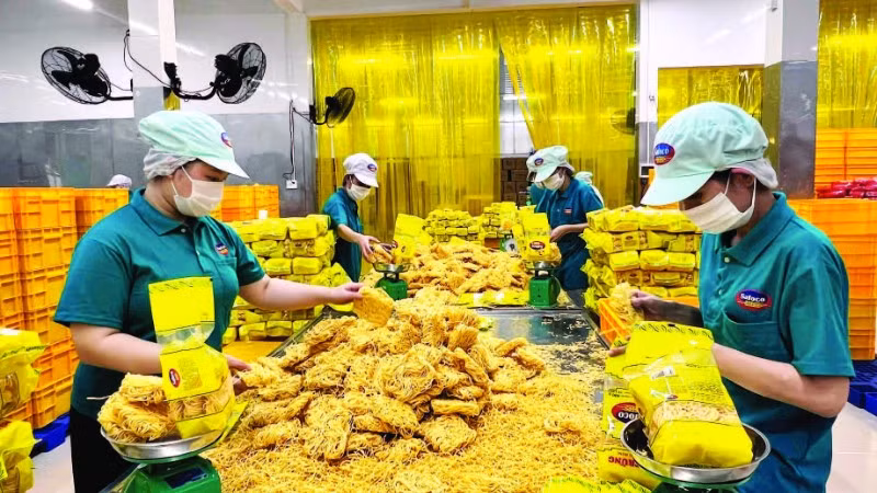 Công nhân Công ty cổ phần Lương thực thực phẩm SAFOCO làm việc trong một dây chuyền sản xuất. (Ảnh CTV)