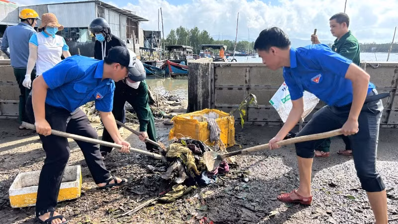 Đoàn viên thanh niên giúp người dân dọn bùn đất sau bão.