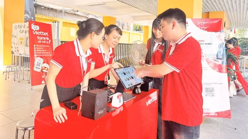 Đại diện Viettel thực hiện thao tác hướng dẫn người dân sử dụng các công cụ chuyển đổi số trong quản lý, kinh doanh ở quy mô hộ gia đình.