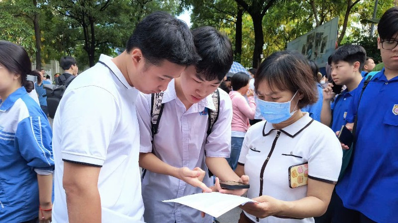 Thí sinh trao đổi sau buổi thi Ngữ văn sáng 26/6 (Ảnh: HỒNG VÂN)