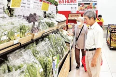 Người tiêu dùng chọn mua rau sạch đạt chứng nhận “Tick xanh trách nhiệm” trong một siêu thị SatraMart ở thành phố.