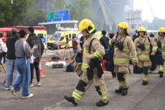 Các nhân viên cứu hộ tại hiện trường vụ cháy. (Ảnh: TTXVN)