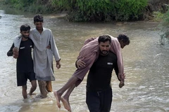 Người dân di chuyển qua đoạn đường bị ngập do mưa lũ tại Pakistan. (Ảnh: Tân Hoa Xã)