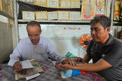 Lương y Nguyễn Văn Chiến chẩn mạch cho người bệnh.