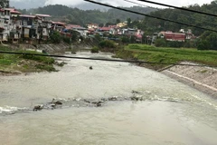 Sau mưa lũ to, hiện một phần đường công vụ cũ vẫn nổi lên, cắt ngang dòng sông Năng. (Ảnh: TUẤN SƠN)