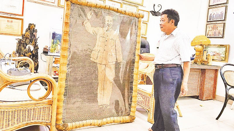 Nghệ nhân nhân dân Nguyễn Văn Trung bên bức chân dung Bác Hồ bằng mây tre vừa hoàn thiện.