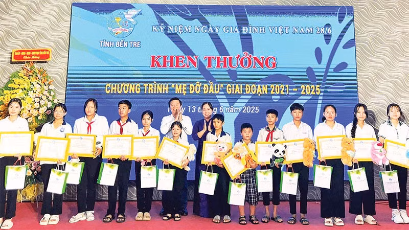 Hội Liên hiệp Phụ nữ tỉnh Bến Tre tặng quà, giấy khen cho các bé mồ côi có thành tích học tập tốt. (Ảnh HOÀNG TRUNG)