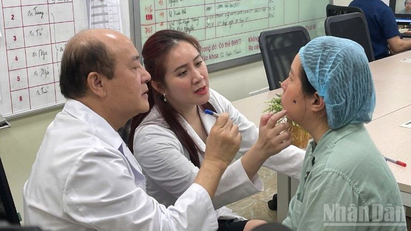 Giáo sư, Tiến sĩ Nguyễn Tài Sơn và Tiến sĩ, bác sĩ Nguyễn Hồng Nhung khám cho bệnh nhân. 