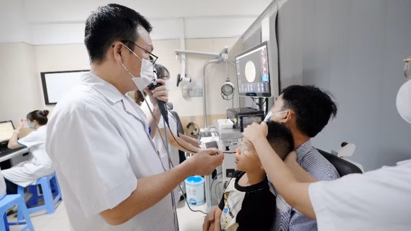 Tiến sĩ, bác sĩ Đào Đình Thi đang nội soi tai mũi họng cho bệnh nhi mắc chứng ngủ ngáy.