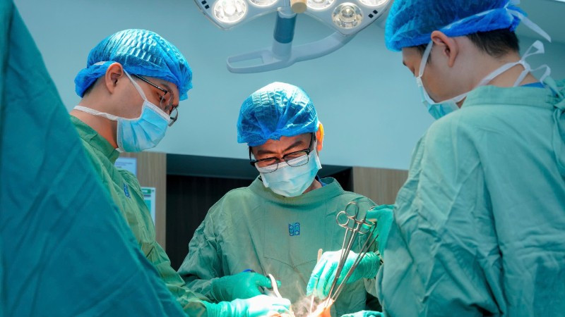 Bác sĩ chuyên khoa II Nguyễn Triệu Vũ, Trưởng khoa Tuyến vú, Bệnh viện Đại học Y Dược Thành phố Hồ Chí Minh và ê-kíp phẫu thuật cho bệnh nhân. 