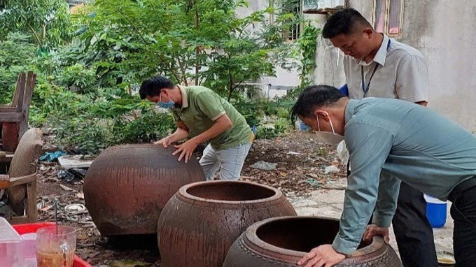 Lật úp các dụng cụ không chứa nước để muỗi không vào đẻ trứng. (Ảnh: HCDC)
