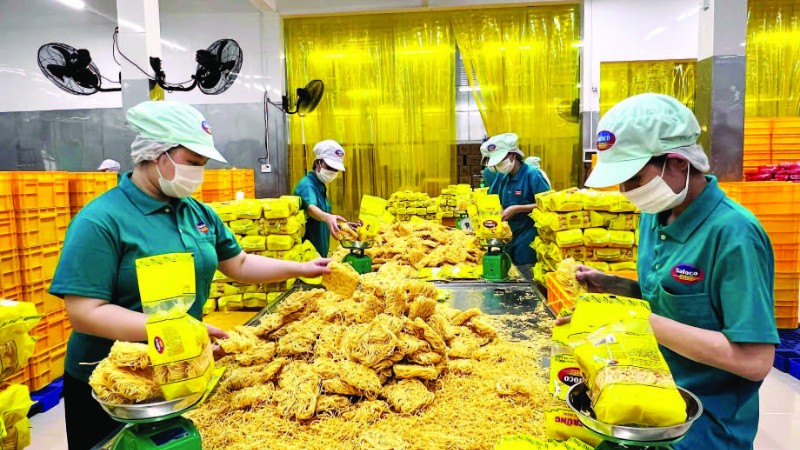 Công nhân Công ty cổ phần Lương thực thực phẩm SAFOCO làm việc trong một dây chuyền sản xuất. (Ảnh CTV)