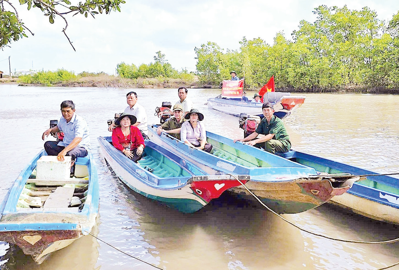 Cán bộ đến tận những căn nhà dân dựng ven sông để trao thẻ cử tri, mang lại niềm vui và sự an tâm cho người dân vùng sâu.
