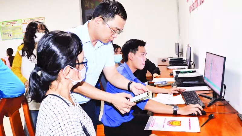 Cán bộ xã Long Thành hướng dẫn người dân nộp hồ sơ trực tuyến.