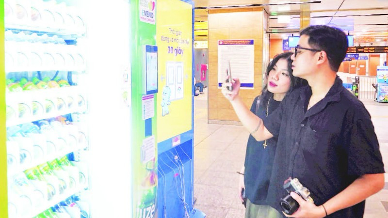 Hành khách mua đồ uống tại máy bán hàng tự động ở nhà ga ngầm của tuyến Metro Bến Thành-Suối Tiên. (Ảnh THẾ ANH)