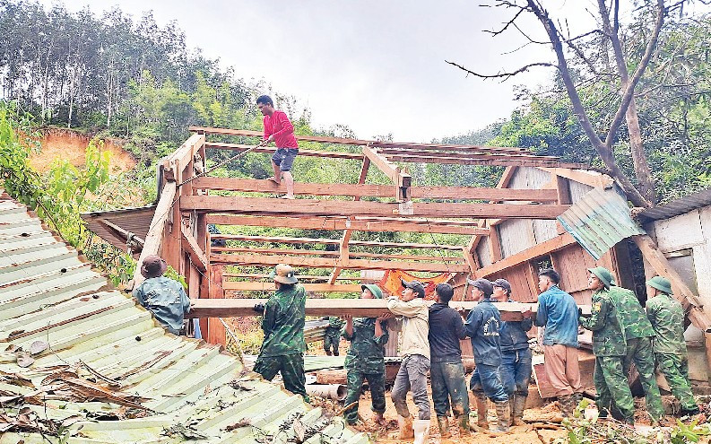 Đồn Biên phòng Anông cùng cán bộ, chiến sĩ xã Avương giúp người dân thôn Atếêp khắc phục hậu quả mưa lũ.