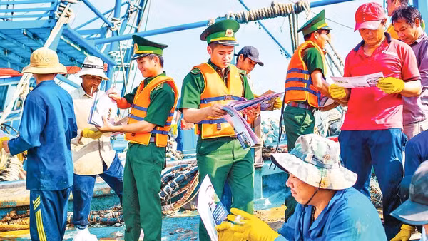 Bộ đội Biên phòng Thành phố Hồ Chí Minh phát tờ rơi tuyên truyền cho ngư dân trên tàu cá.
