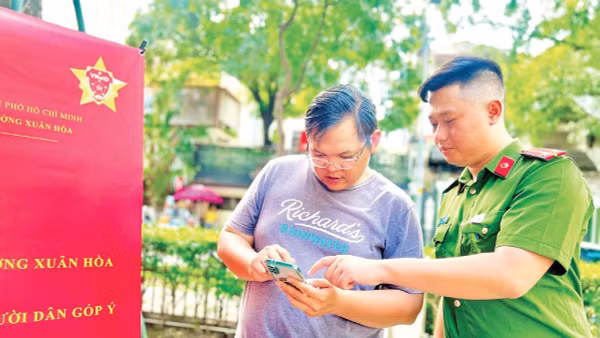 Công an phường Xuân Hòa hướng dẫn người dân thao tác, sử dụng các tiện ích trên Ứng dụng VNeID. 