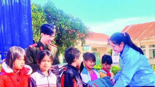 Chị Huỳnh Thị Mai Yến trao áo ấm tặng các em học sinh đồng bào dân tộc thiểu số.