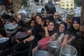 Người dân Palestine phải di dời chờ nhận thực phẩm miễn phí từ một trung tâm phân phối thực phẩm ở Thành phố Gaza, ngày 14/7/2025.(Ảnh: THX)