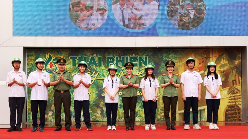 Ban tổ chức chương trình tặng mũ bảo hiểm cho các em học sinh Trường trung học phổ thông Thái Phiên.