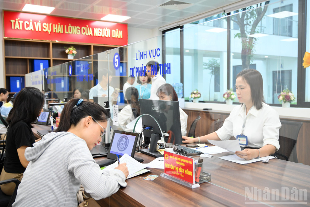 Khi tới số thứ tự, người dân sẽ đến quầy tiếp nhận hồ sơ và tiến hành làm việc với cán bộ tiếp nhận. ndo_br_chinh-quyen-2-cap-7120.jpg